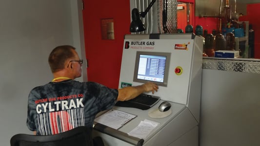 man using a control panel to fill gas cylinders