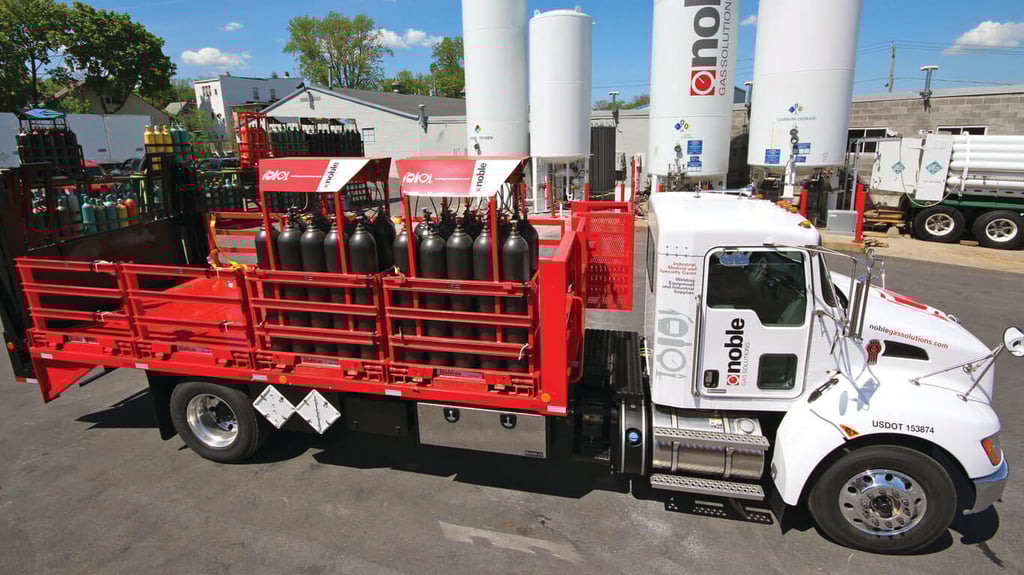 Two Weldcoa gas pallets filled with gas cylinders secured on a truck