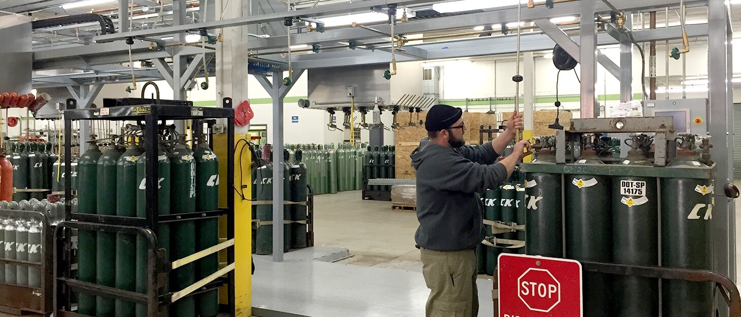 man connecting a gas cylinder to a filling hose