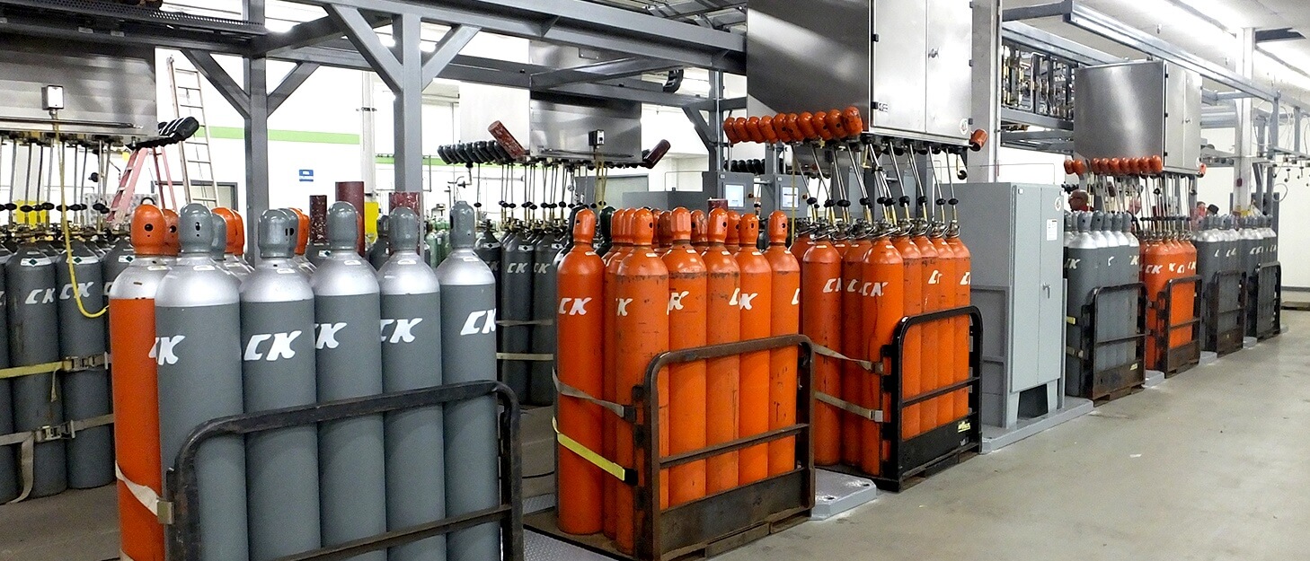 gas cylinders in gas packs being filled by a automated filling station