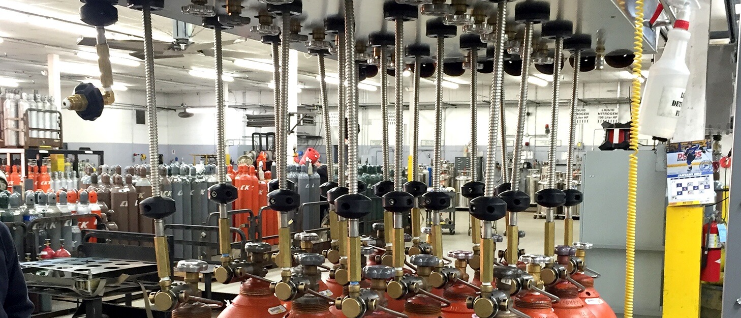 close up of gas cylinders being filled by a automated filling station