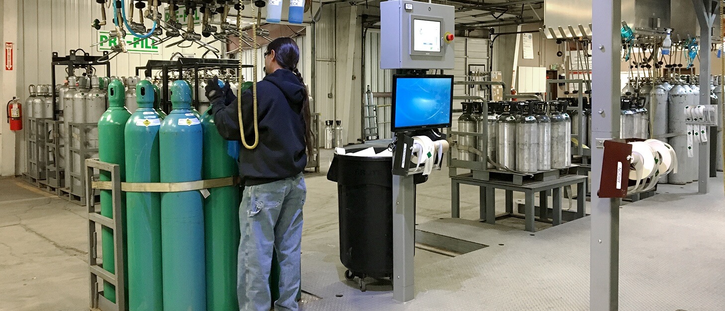 man in a gas cylinder filling plant putting a protection cap on a gas cylinder 