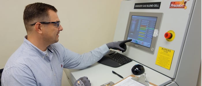 man working at a control panel for a gas cylinder fill system