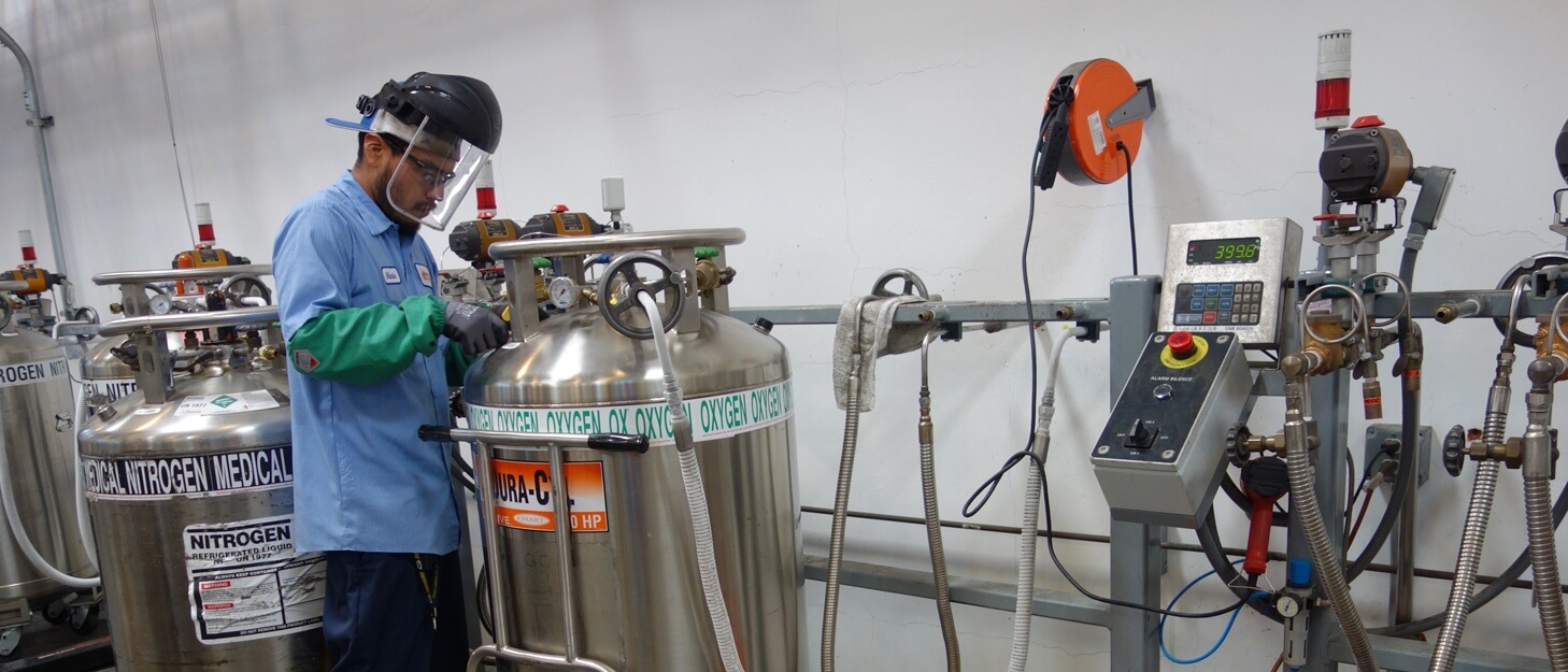 man filling a large gas cylinder with oxygen