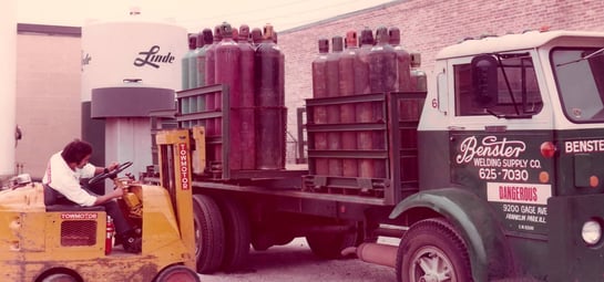 Gas cylinders in a gas pallet being loaded on to a truck with a forklift