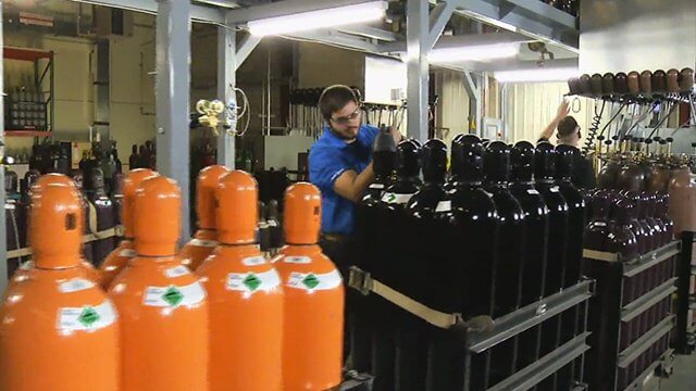 man filling cylinders at A-OX Welding Supply's fill plant