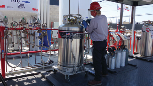 man filling a large gas cylinder