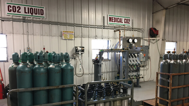 various gas cylinders in gas packs and gas pallets near gas cylinder filling equipment