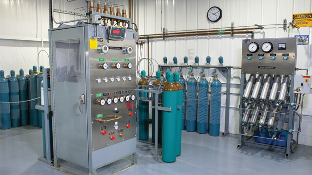 gas cylinders in various racks and holders around gas cylinder filling equipment