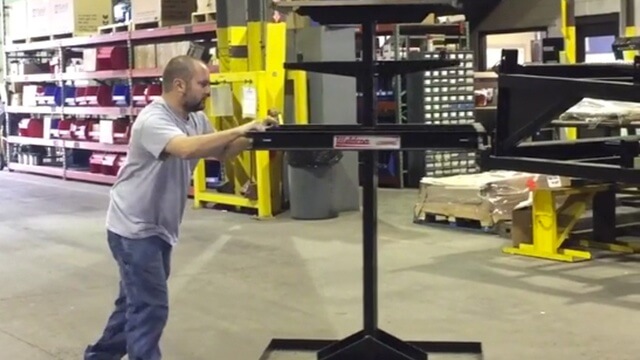 Man pushing a Weldcoa LowPro M1 12 cylinder cart