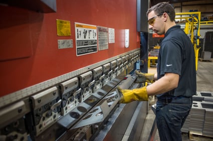 man using a press to bend metal